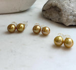Close-up of 11.3mm golden Edison pearl stud earrings showing their rich natural color and mirror-like shine.