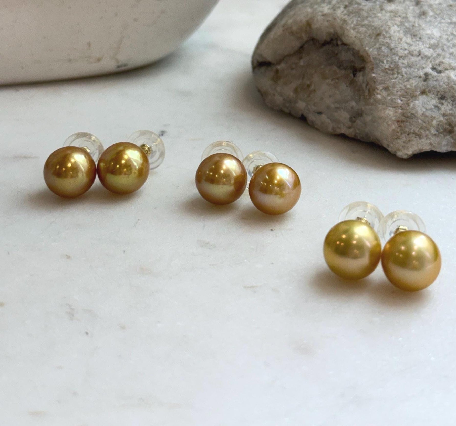 Close-up of 11.3mm golden Edison pearl stud earrings showing their rich natural color and mirror-like shine.