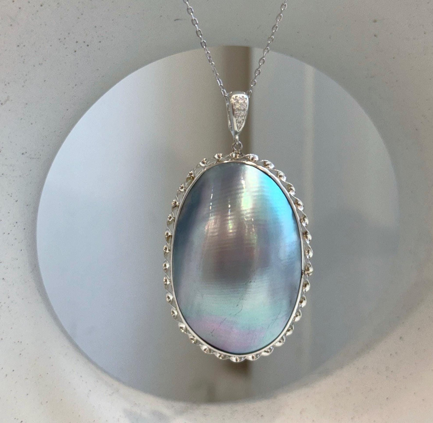Genuine ocean Mabe pearl pendant with blue iridescent glow