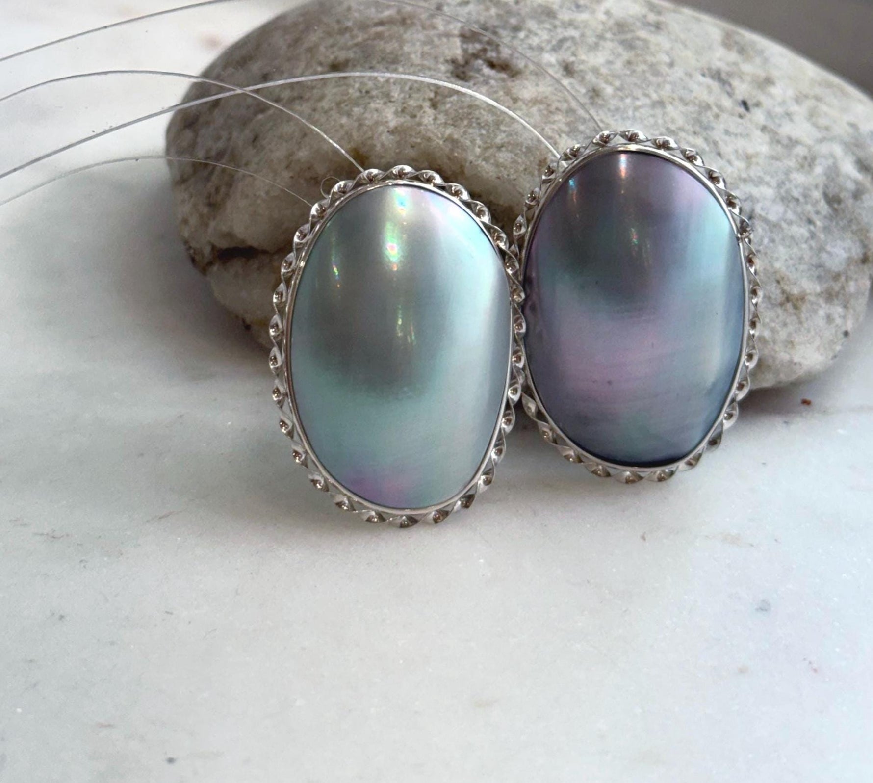 Large ocean Mabe pearl earrings with luminous blue iridescent tones