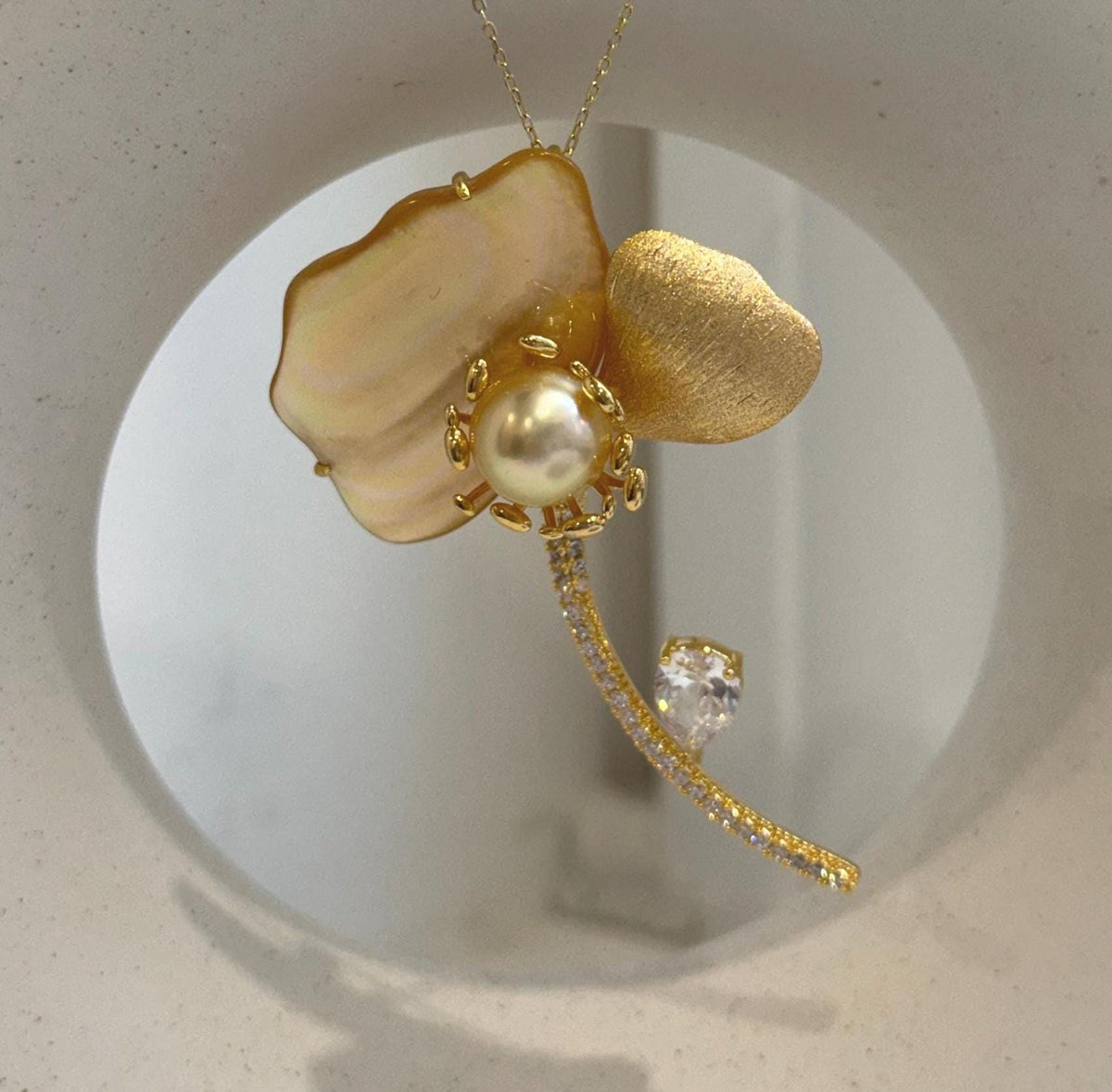 2-in-1 golden pearl brooch and pendant with elegant floral design and extreme mirror luster.