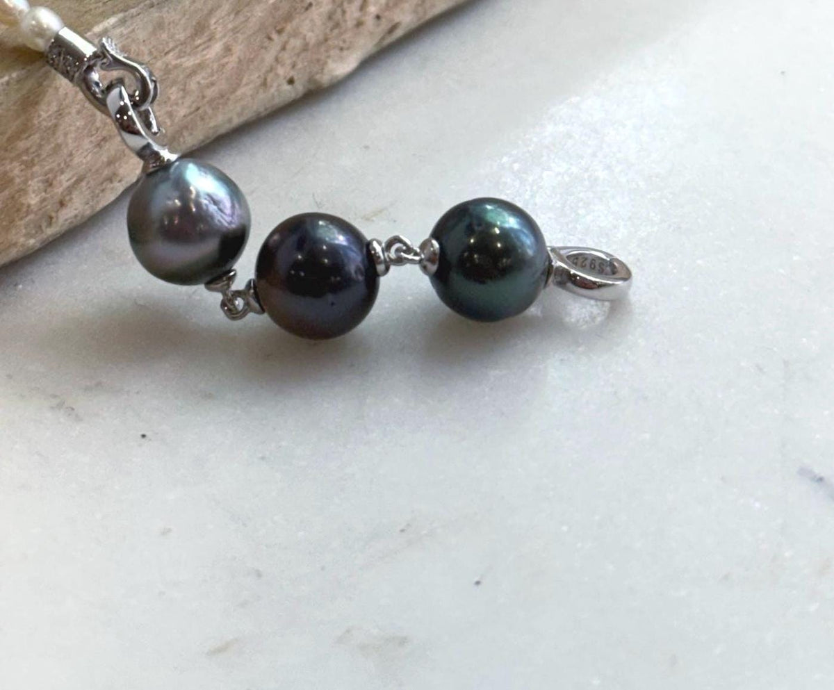 Close-up of metallic Tahitian pearls with peacock green and chocolate overtones.