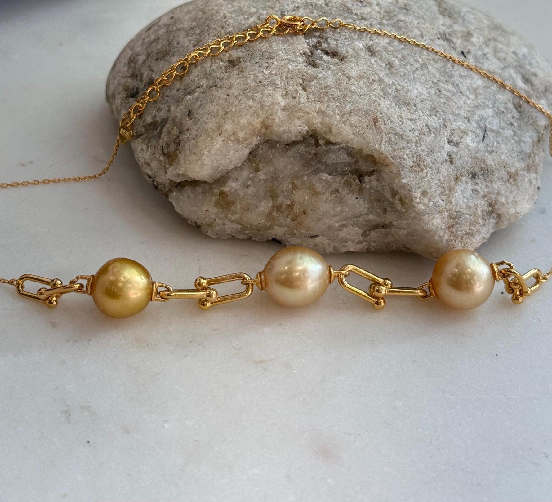 Three pearl station necklace with bright mirrored luster and gold tone chain