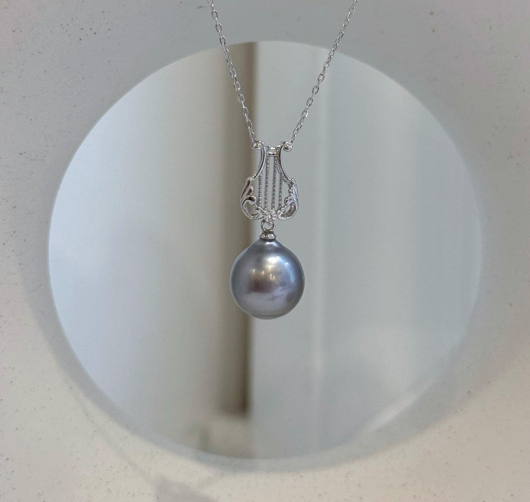 Platinum Tahitian pearl necklace pendant with elegant lyre setting