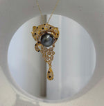 Vintage leopard brooch with lustrous 10.7mm Tahitian platinum pearl centerpiece.