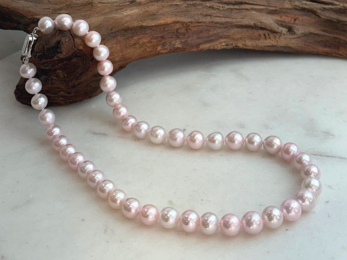 Close-up of genuine pale pink freshwater pearls showing beautiful natural color and highly reflective luster.