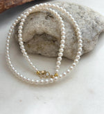 Elly’s elegant white pearl necklace strand featuring luminous pearls and luxurious 18K Au750 gold finishing.