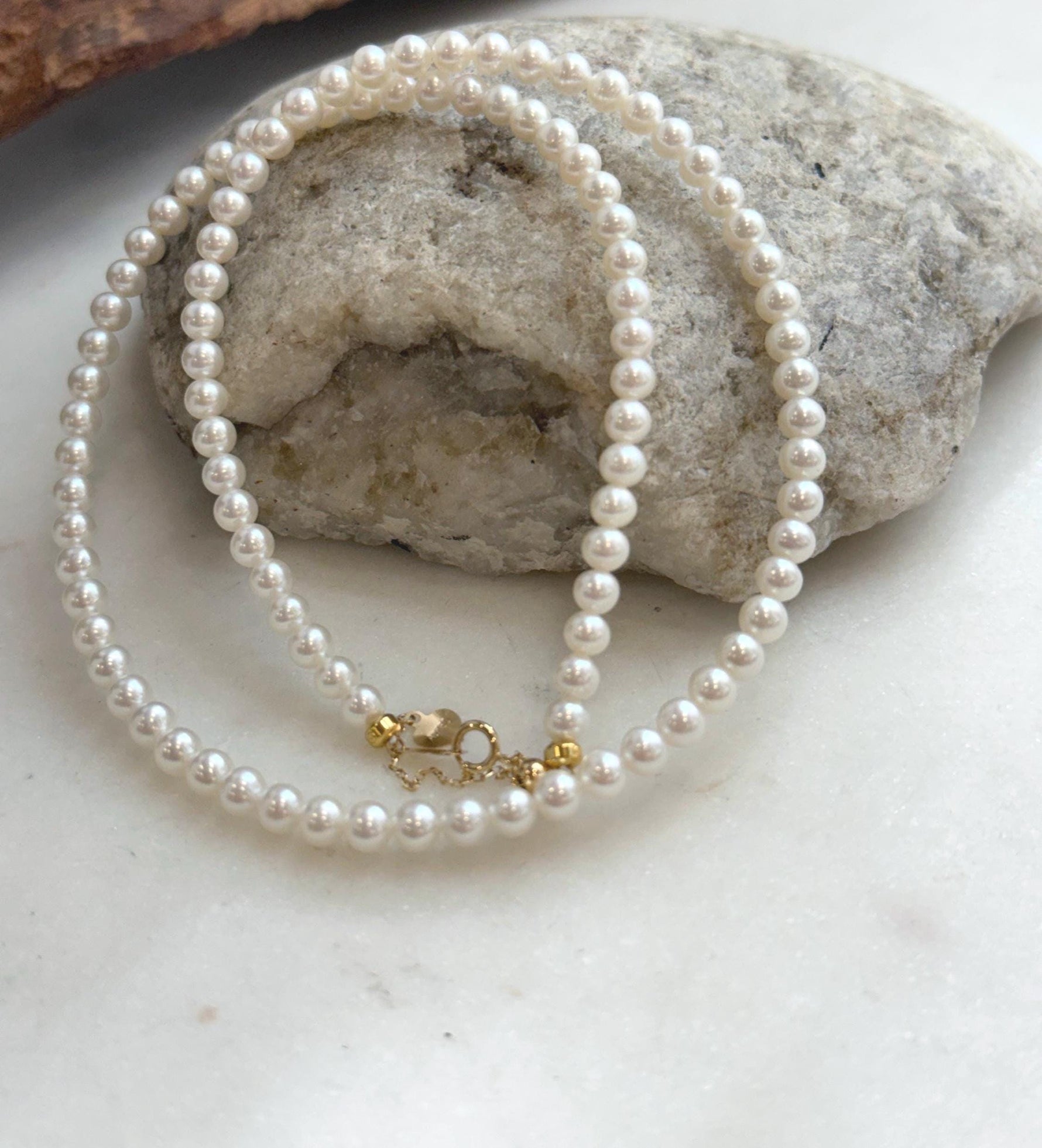 Elly’s elegant white pearl necklace strand featuring luminous pearls and luxurious 18K Au750 gold finishing.
