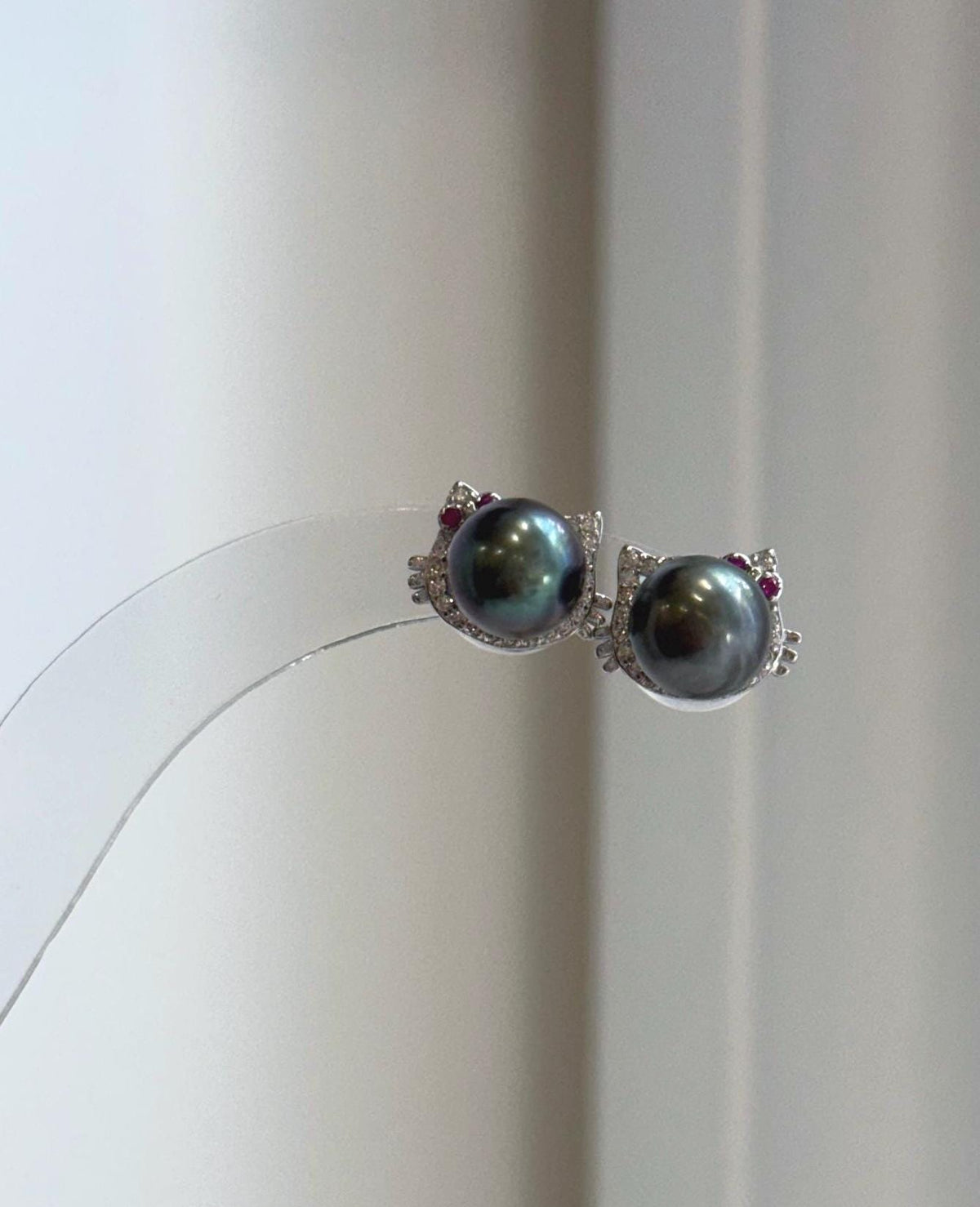 Genuine Tahitian saltwater pearl cat earrings featuring rich peacock hunter tones and brilliant mirror luster.