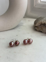 Close-up of 10.3mm mauve Edison pearl studs showing smooth surfaces and reflective mirror luster.