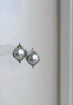 Genuine saltwater Akoya pearl earrings featuring rare ocean blue silver tones and brilliant reflective luster.