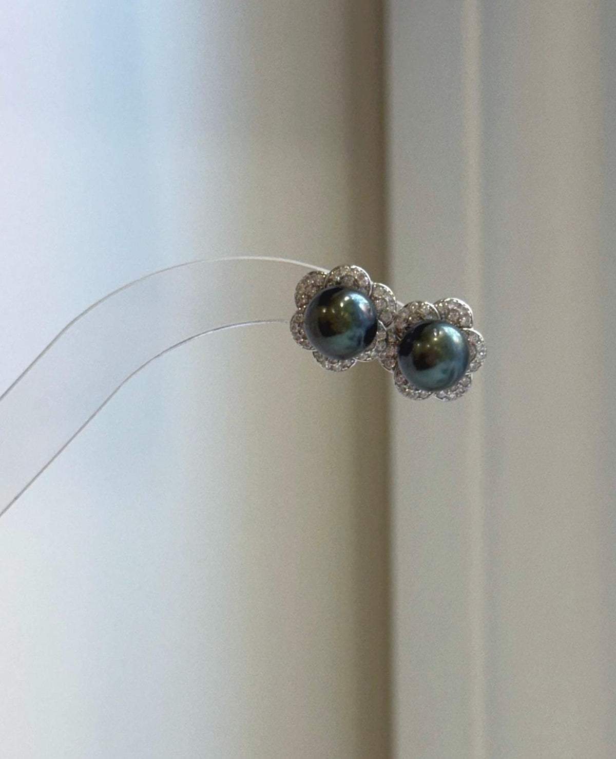 Tahitian hunter green pearl stud earrings with highly reflective mirror luster and delicate silver flower earring jackets.