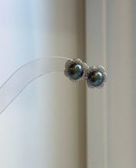 Tahitian hunter green pearl stud earrings with highly reflective mirror luster and delicate silver flower earring jackets.