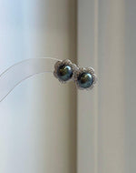 Tahitian hunter ocean pearl stud earrings featuring naturally rich color and reflective luster with floral silver details.