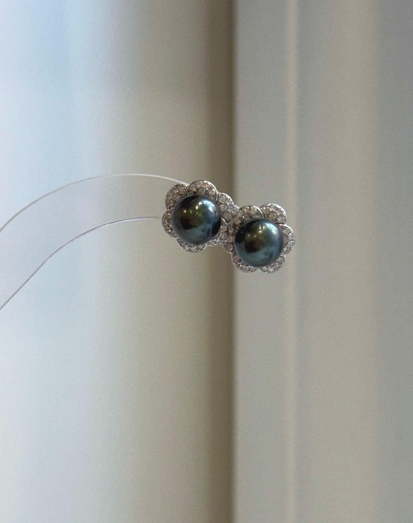 Tahitian hunter ocean pearl stud earrings featuring naturally rich color and reflective luster with floral silver details.
