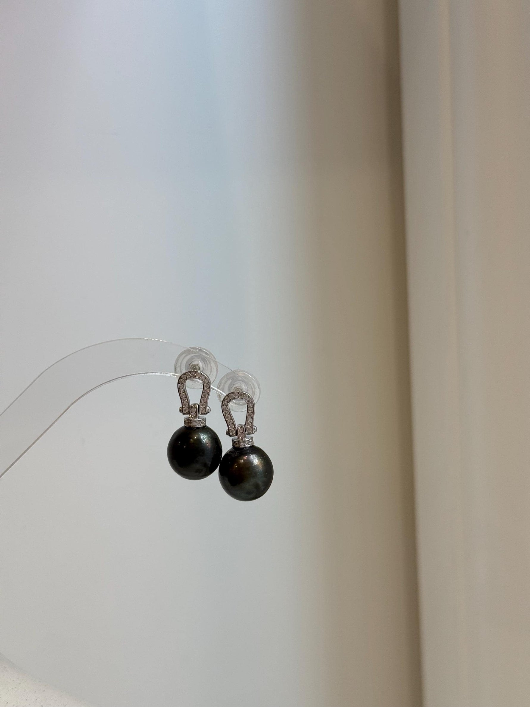 Tahitian black pearl earrings with vivid peacock hunter overtones and smooth high-luster surfaces.