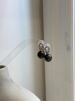 Close-up of genuine Tahitian saltwater pearls with intense peacock green overtones and extreme metallic mirror luster.