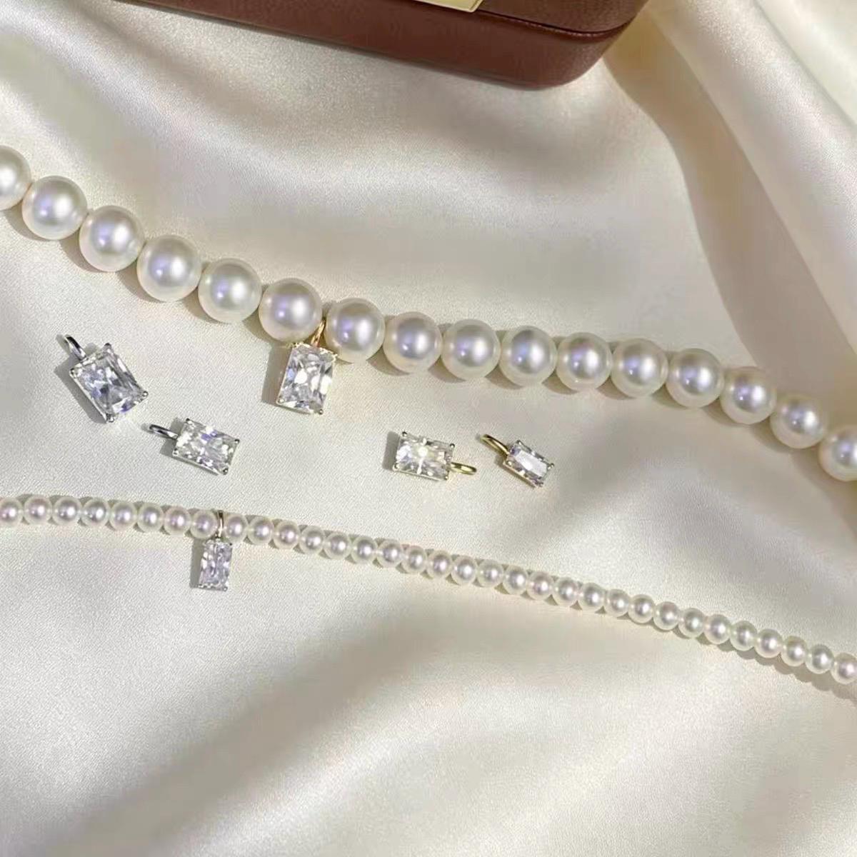 Sparkling clear emerald cut moissanite pendant charm with a minimalist solid 18K gold setting.