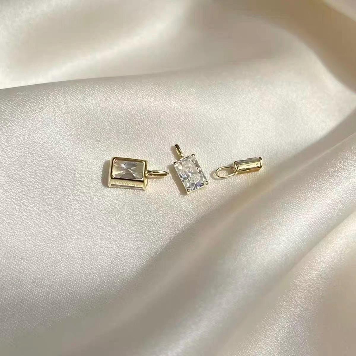 Brilliant rectangular moissanite jewelry charm featuring an elegant emerald cut and Au750 18K gold.