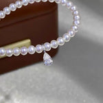 Clear teardrop moissanite charm featuring a brilliant pear cut and delicate Au750 18K gold setting.