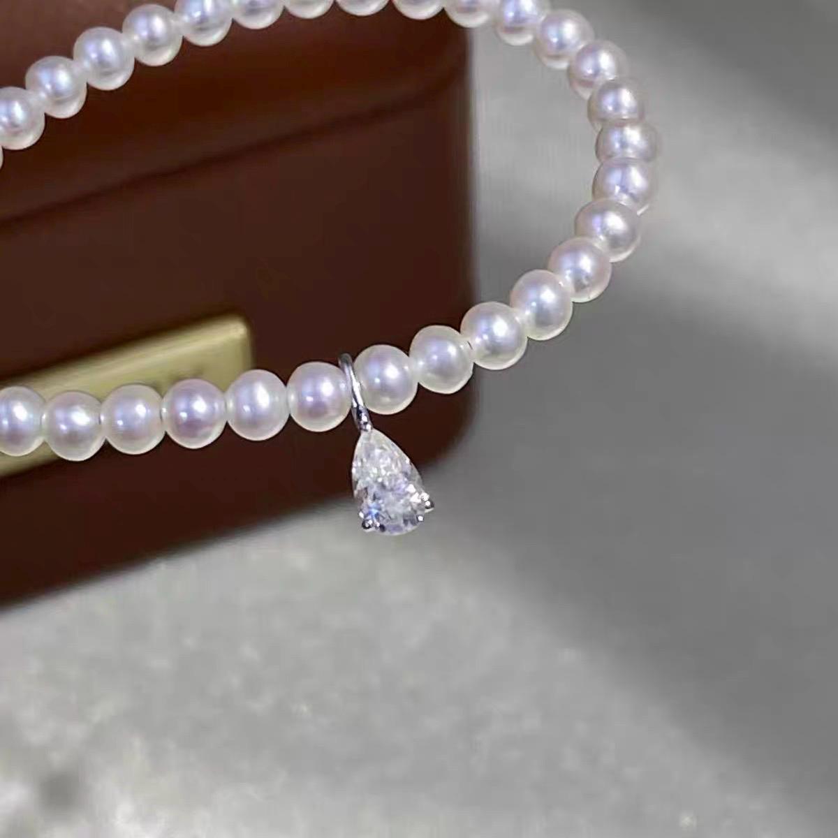 Clear teardrop moissanite charm featuring a brilliant pear cut and delicate Au750 18K gold setting.
