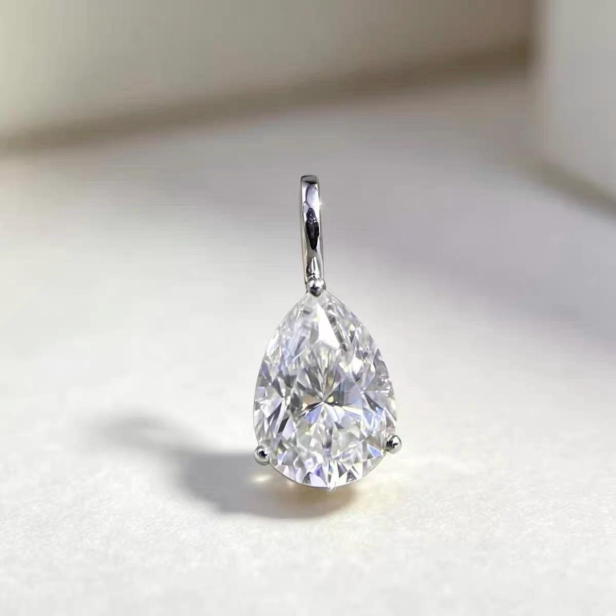 Sparkling pear shaped moissanite pendant charm in solid 18K gold for elegant jewelry making.
