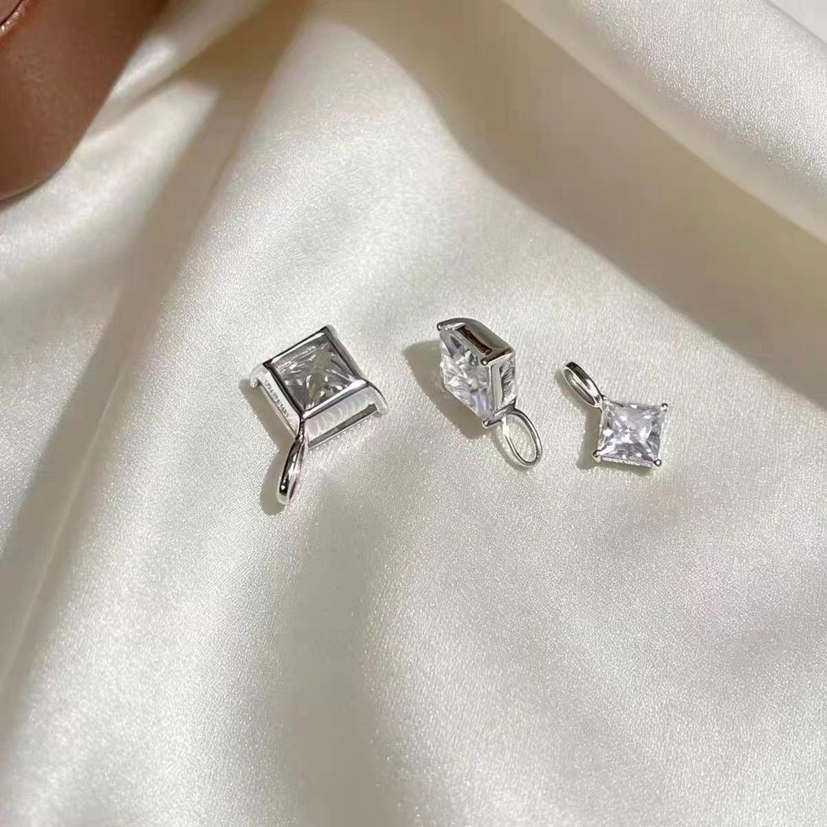 Sparkling square moissanite charm set diagonally in an elegant diamond shape with solid 18K gold.