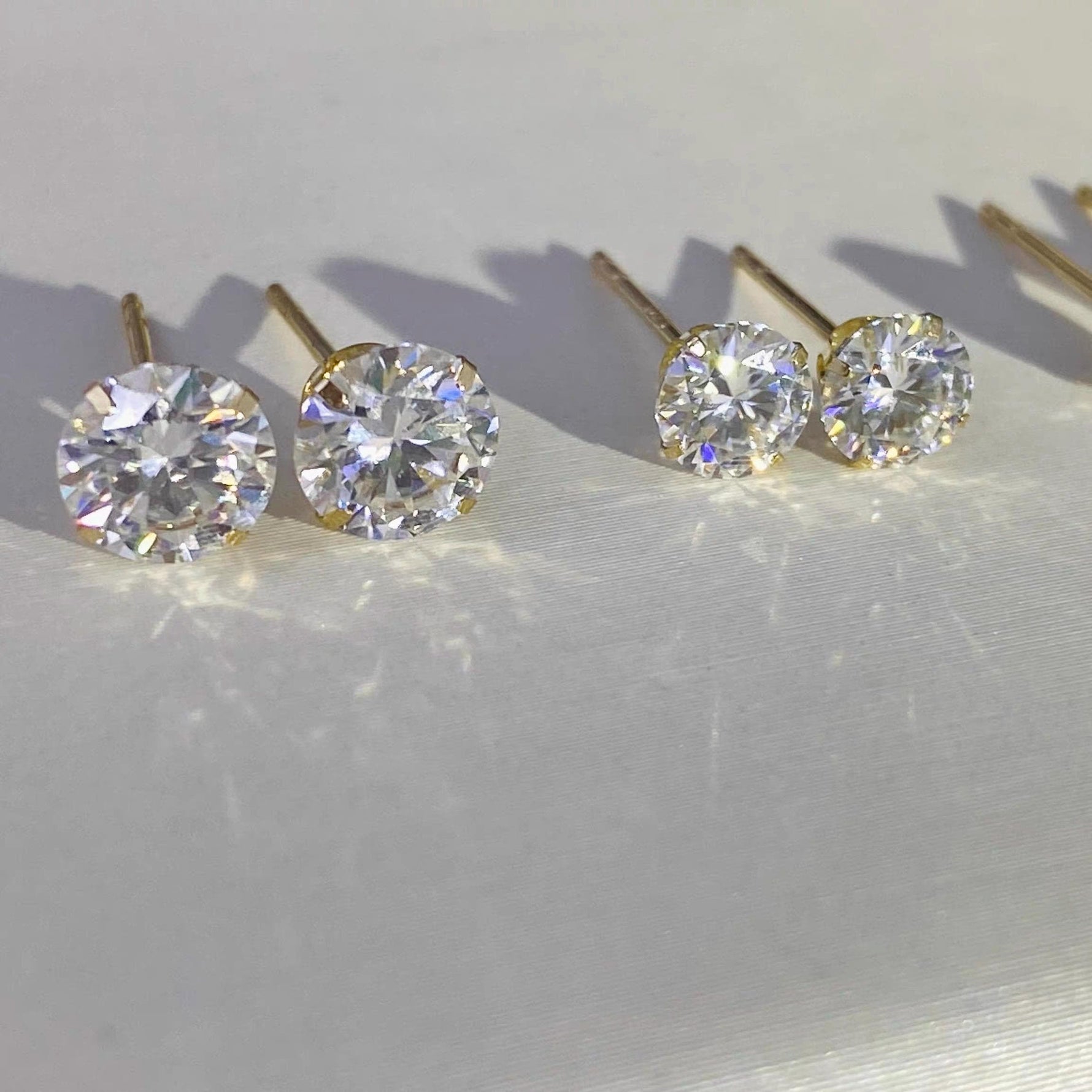 Round moissanite stud earrings in solid 14K gold with classic 4-prong settings and brilliant sparkle.
