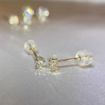 Close-up of round brilliant moissanite gemstones secured in elegant 4-prong 14K gold settings.