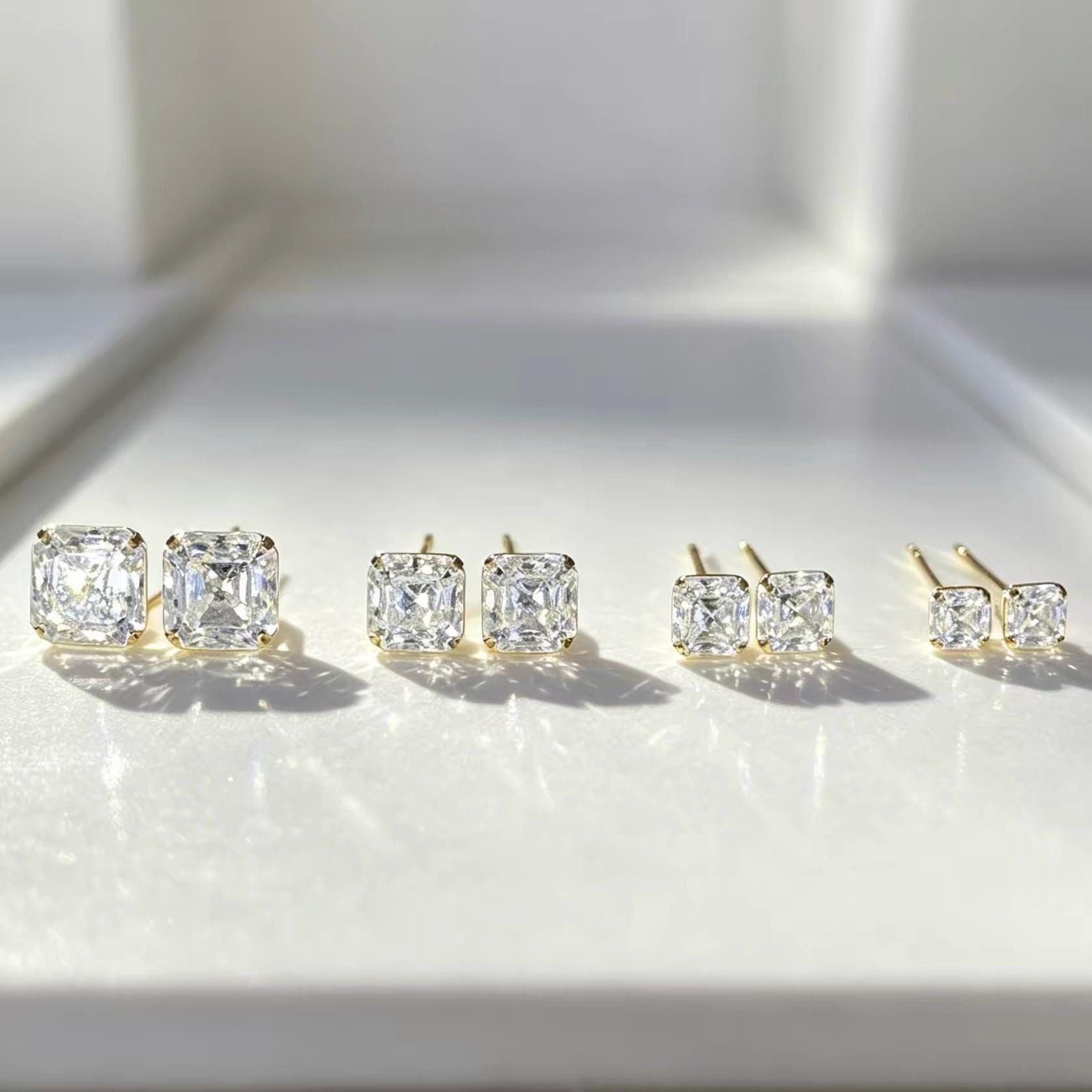 Asscher cut moissanite stud earrings in solid 14K yellow gold with classic 4-prong settings.