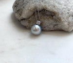 Close-up of an 11.9mm genuine Tahitian pearl showing its natural color, smooth surface and reflective mirror luster.