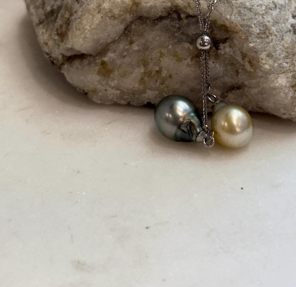 Unique two pearl pendant design combining a warm golden South Sea pearl with a Tahitian ocean pearl.