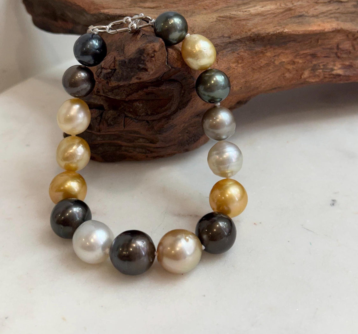 Multicolor ocean pearl bracelet featuring golden, white, peacock green and dark pearls