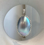 Large ocean Mabe pearl pendant with luminous blue iridescent tones