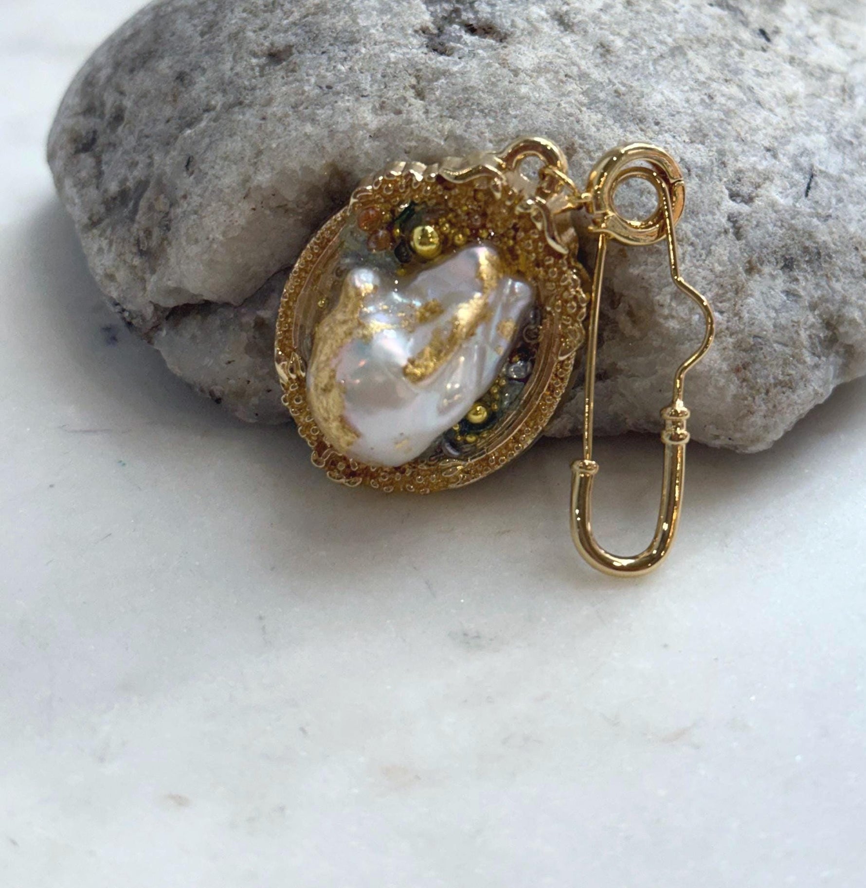 White iridescent freshwater baroque pearl vintage brooch pendant with gold foiled setting and extreme luster.