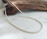 Elly’s white small pearl necklace strand with extreme mirror luster and solid 18K Au750 gold clasp.