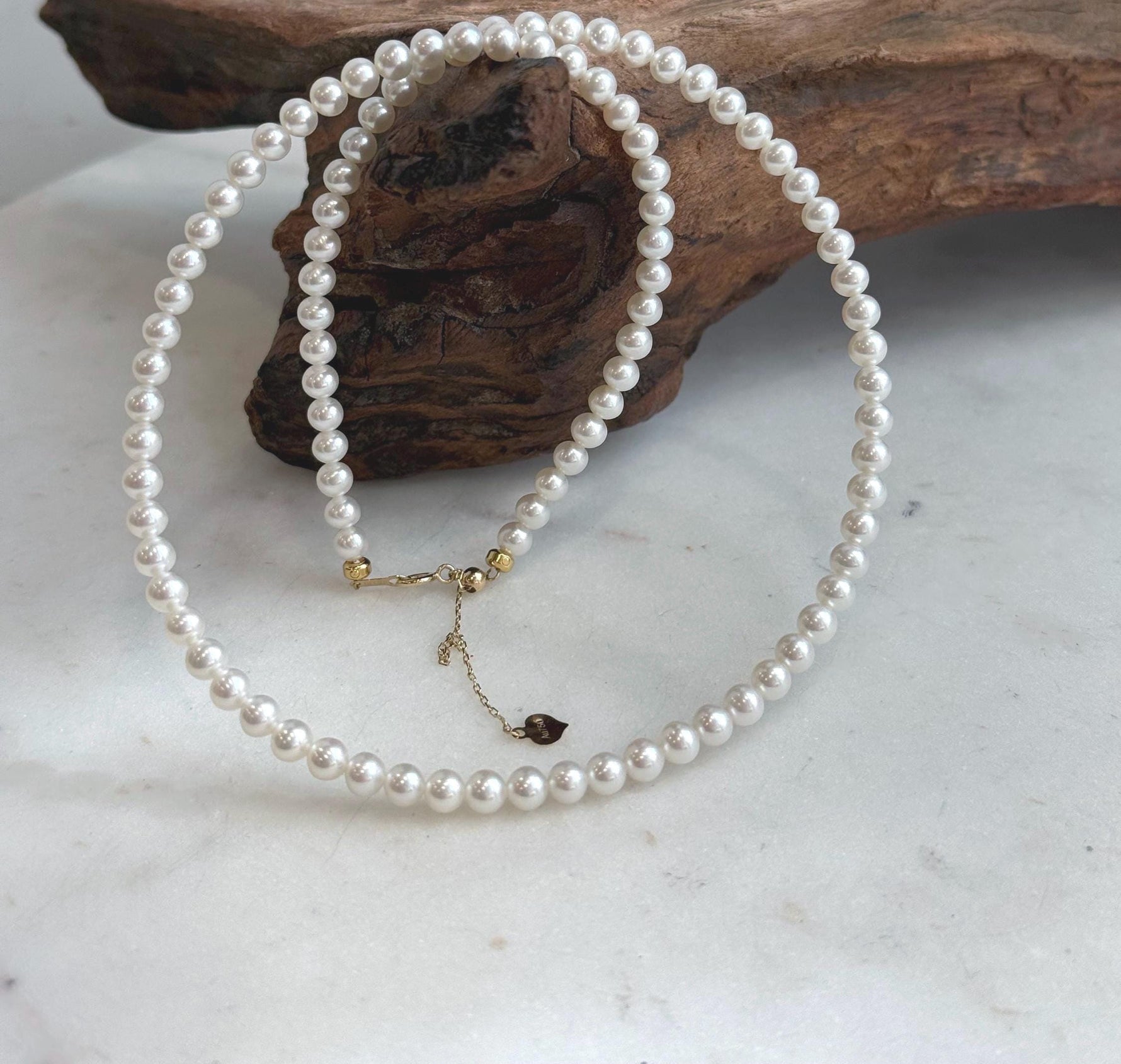 Top 5A white pearl necklace featuring luminous small pearls and an elegant 18K solid gold clasp.