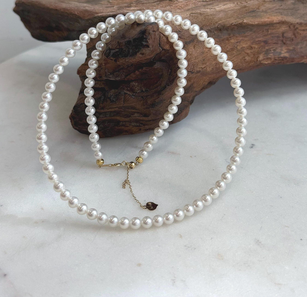 Luxury white pearl necklace with beautifully matched small pearls and polished 18K Au750 gold clasp.