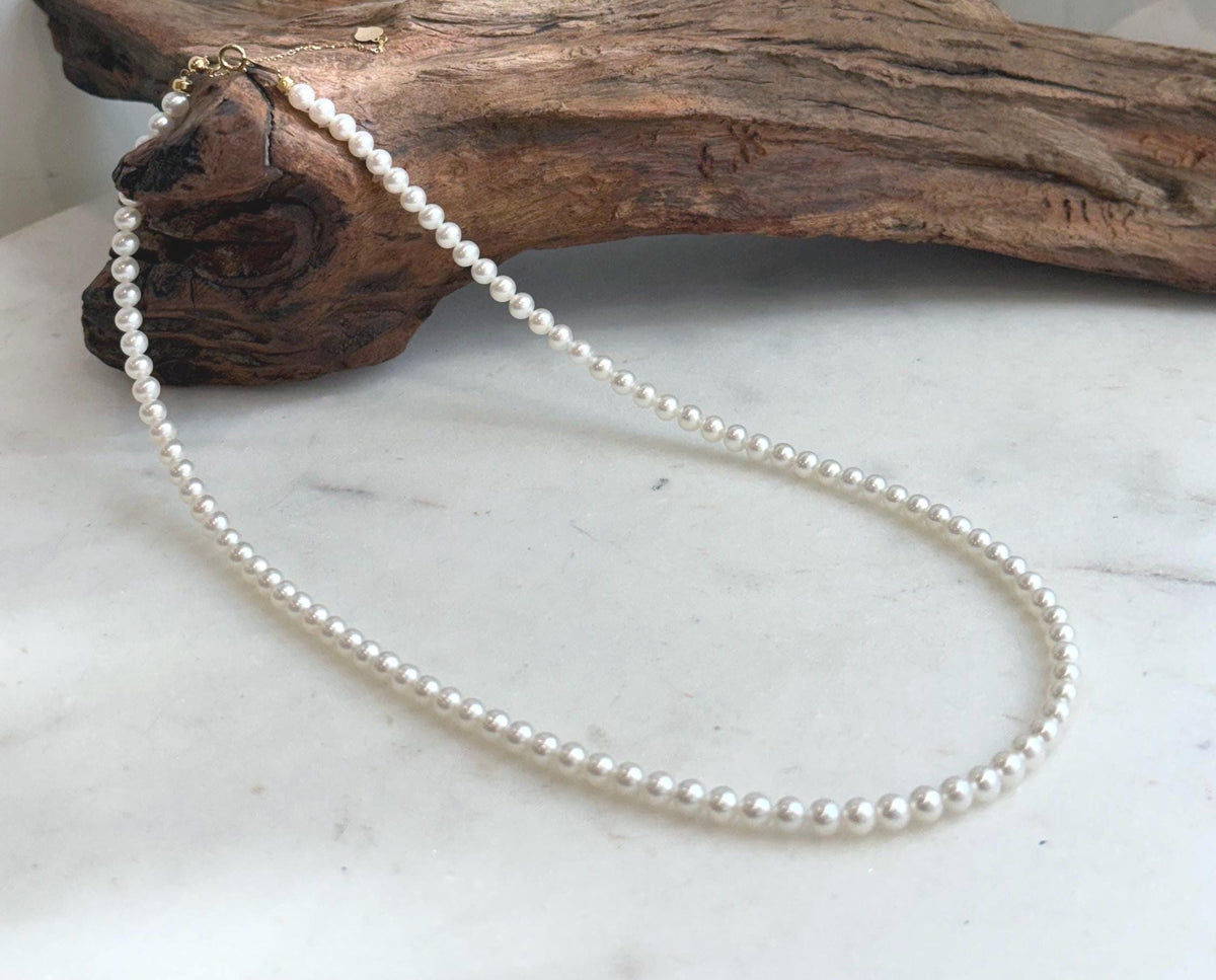 Delicate white pearl necklace featuring Top 5A quality pearls with exceptional shine and 18K gold hardware.