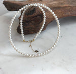 Timeless white small pearl strand with radiant mirror luster and refined solid 18K Au750 gold clasp.
