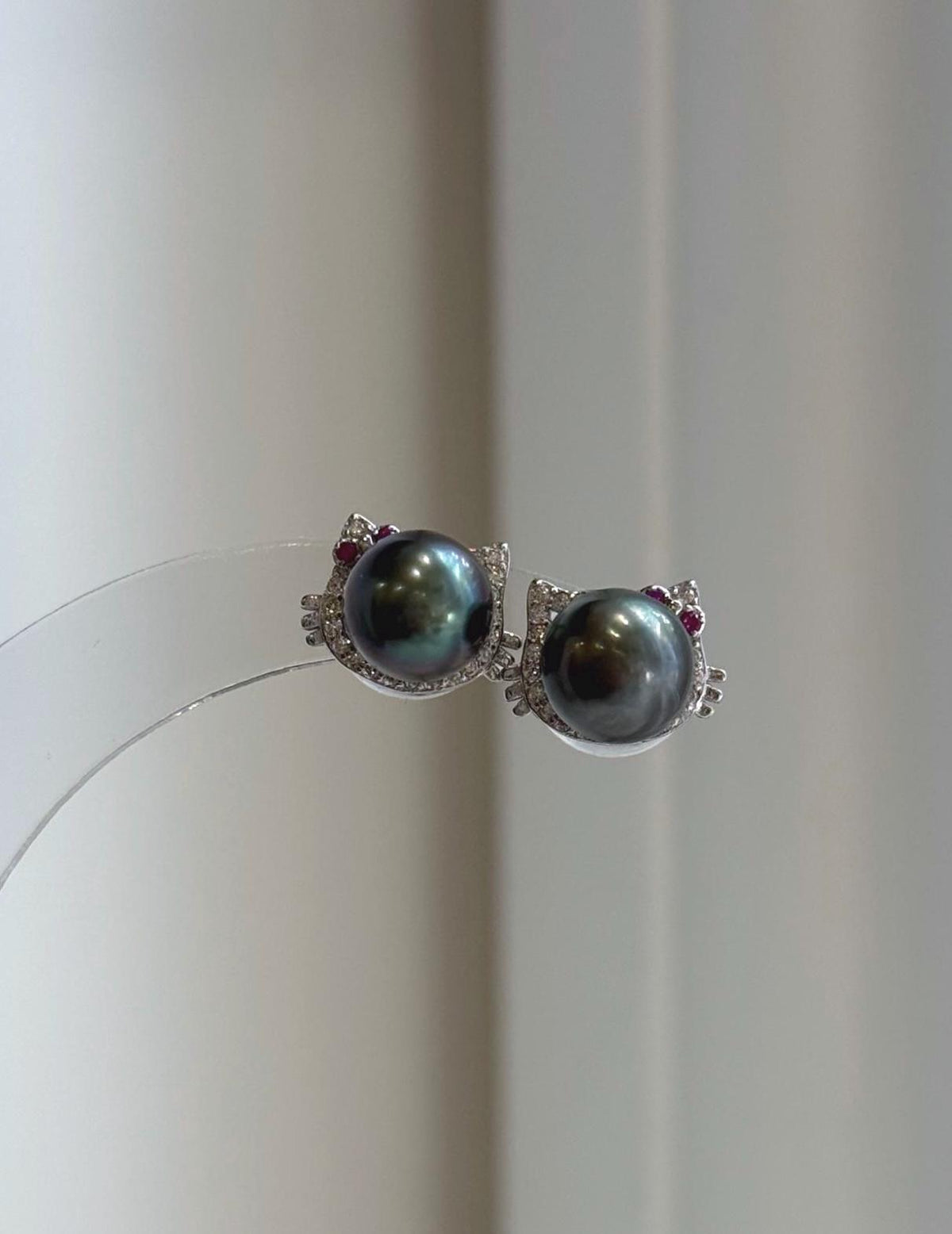 Genuine saltwater Tahitian pearl earrings with playful cat design and vivid peacock green overtones.
