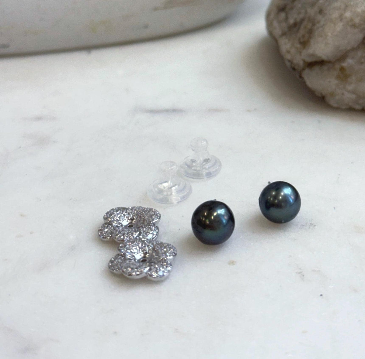 Genuine Tahitian saltwater pearl earrings featuring rich hunter green color and elegant sterling silver floral jackets.