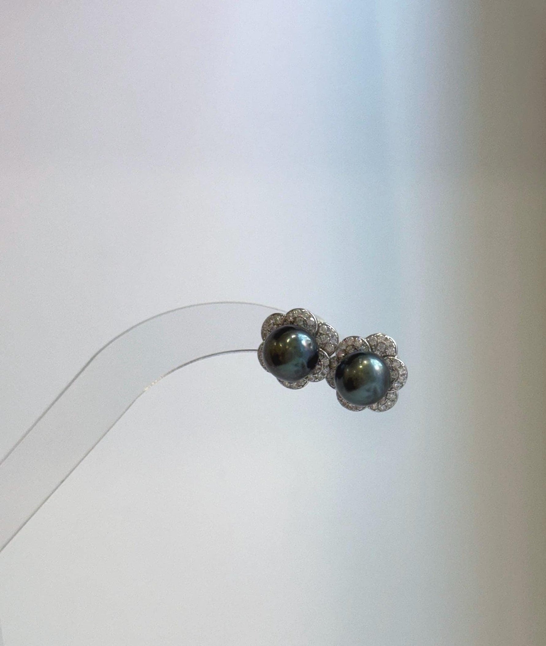 Genuine saltwater Tahitian pearl earrings with metallic mirror luster and decorative S925 silver flower jackets.