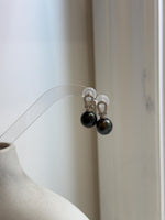 Natural Tahitian ocean pearl earrings displaying deep hunter green and peacock colors with brilliant reflective luster.