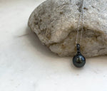 Close-up of 10mm Tahitian pearl pendant showing mirror-like luster and natural color