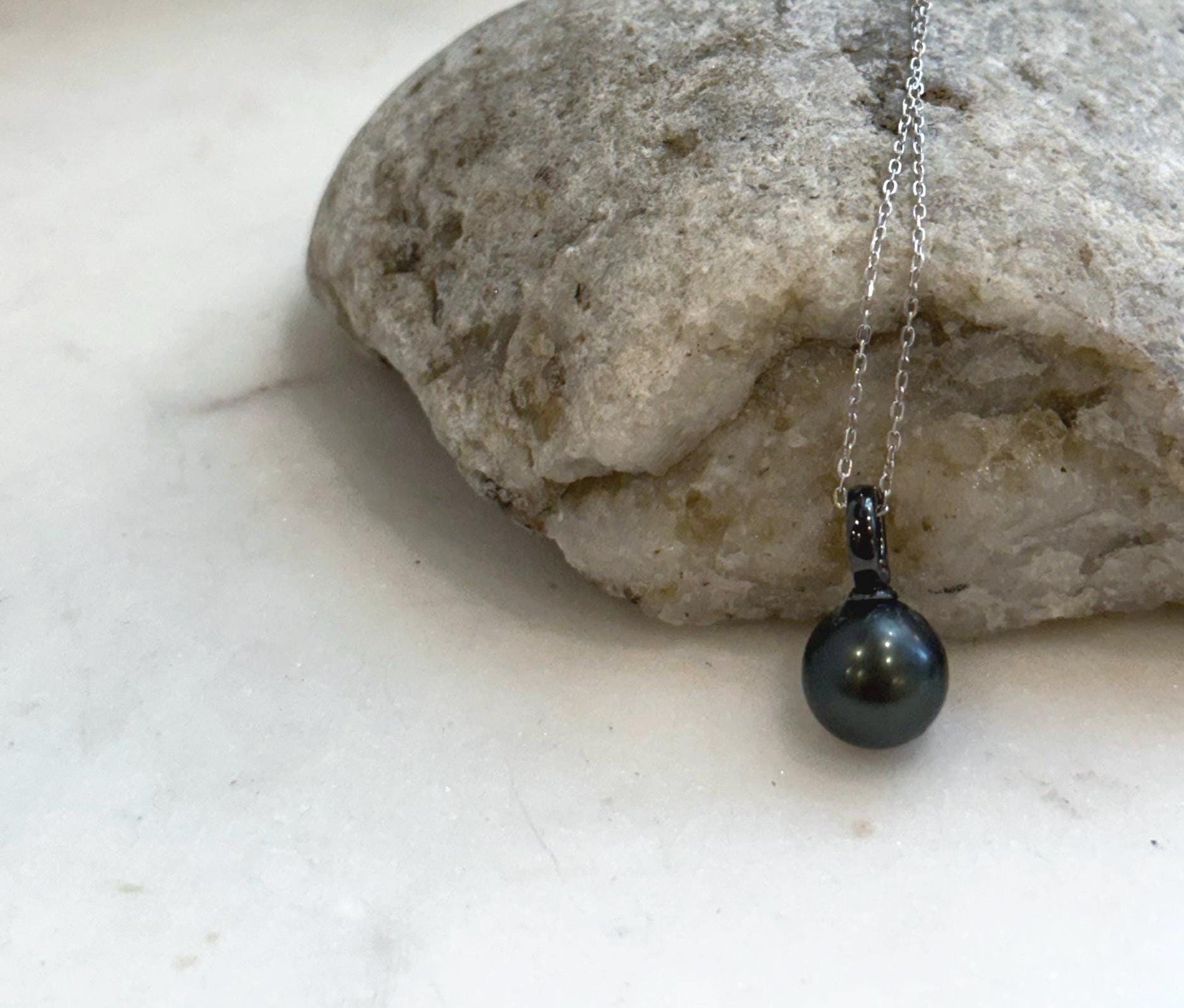 Close-up of 10mm Tahitian pearl pendant showing mirror-like luster and natural color