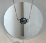 Close-up of a 12.7mm Tahitian pearl pendant showing its natural color, surface and reflective mirror luster.
