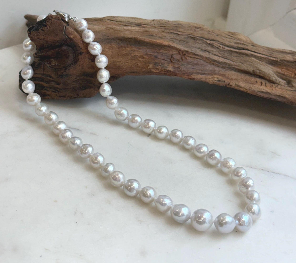 White iridescent freshwater pearl necklace with 7.5–10.4mm graduated pearls and extreme mirror luster.