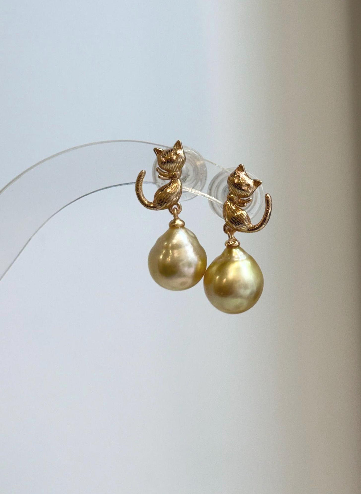 Genuine saltwater South Sea pearl cat earrings with deep golden tea tone and elegant sterling silver design.