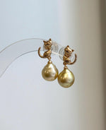 Luxury golden South Sea pearl earrings with playful cat design, extreme luster, and S925 sterling silver.